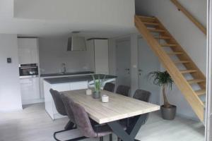 a dining table and chairs in a kitchen with a staircase at Holiday cottage with sauna in Zeeland in Stavenisse