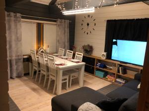 索特的住宿－Syöte Huuhkamajat Cottage，客厅配有餐桌和电视