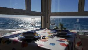 stół z 2 kieliszkami do wina i stół z widokiem na ocean w obiekcie Beachfront 82 w mieście Torrox Costa