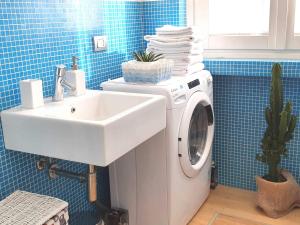 uma casa de banho com uma máquina de lavar roupa e um lavatório em Corso Vercelli Apartment em Milão