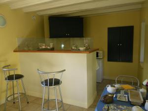 a kitchen with two bar stools and a counter at La Petite Varenne in Turny