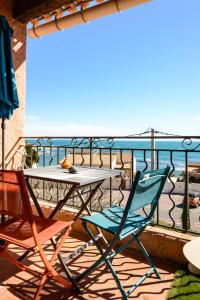 una mesa y sillas en un balcón con vistas al océano en A 2 pas de la Mer en Sausset-les-Pins