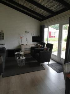 シンペルフェルトにあるRustige, gelijkvloerse vakantiewoning met 2 slaapkamers in Simpelveld, Zuid-Limburgのリビングルーム(ソファ、椅子、テーブル付)