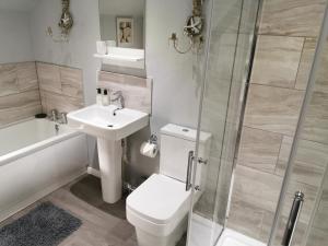 un bagno con wc, lavandino e doccia di The Saddlery Holiday Cottage - Near Wolds And Coast a North Thoresby Altre 23 foto