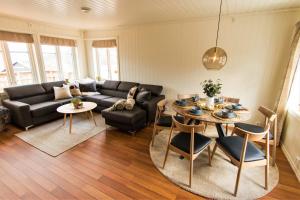 un soggiorno con divano e tavolo di Bjørkelia Lodge a Vassenden