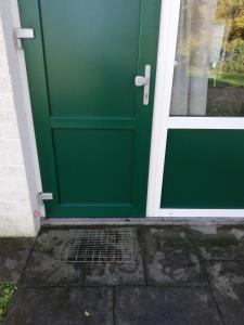 eine grüne Haustür eines Hauses in der Unterkunft Rustige, gelijkvloerse vakantiewoning met 2 slaapkamers in Simpelveld, Zuid-Limburg in Simpelveld
