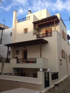 un gran edificio blanco con balcones. en Independent AGAPITOS APART , 2BDRM, private patio, en Naxos Chora