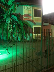 a fence in front of a building with a house at Beach House Floripa - Sunset in Florianópolis