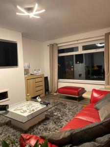 Exmouth holiday home في اكسماوث: غرفة معيشة مع أريكة حمراء وطاولة