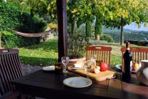 un tavolo con una bottiglia di vino e bicchieri di Country Villa La Bella Vista a Ponte Nuovo