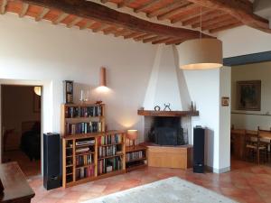 een woonkamer met een boekenplank en een open haard bij Country Villa La Bella Vista in Ponte Nuovo