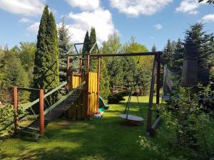 a playground in a yard with a swing at Domek Epona in Szklarska Poręba