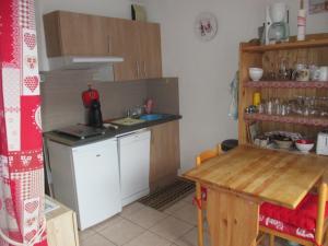 uma pequena cozinha com um lavatório e um balcão em appartement 4 personnes Armancette em Les Contamines-Montjoie