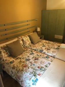 1 dormitorio con 1 cama con colcha de flores en Valle del sol I, en Pajares