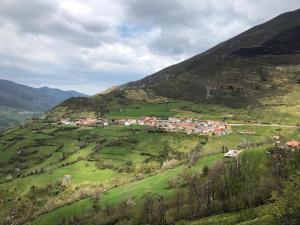 a small town on a hill in a green field at Valle del sol I in Pajares