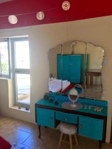 a blue dressing table with a mirror in a room at Casa Montegri 1 in Hal Ghaxiak