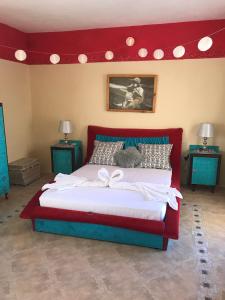 a large bed with a red headboard in a bedroom at Casa Montegri 1 in Hal Ghaxiak
