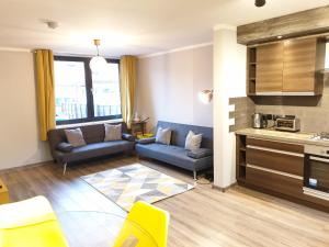 a living room with a couch and a kitchen at Beautiful 2 Bedroom with BT Sports, WIFI and free parking in Birmingham