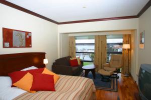 FitjarにあるFitjar Fjordhotellのベッドルーム1室(ベッド1台付)、リビングルームが備わります。