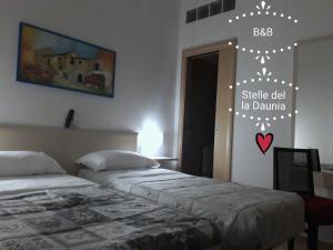 a bedroom with two beds and a sign on the wall at B&B Stelle Della Daunia in San Severo