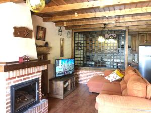 sala de estar con sofá y chimenea en Casa Rural El Castaño, en Navalguijo