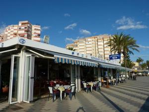 restauracja ze stołami i krzesłami na ulicy w obiekcie Beachfront 82 w mieście Torrox Costa