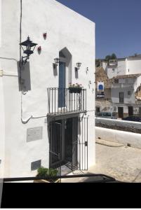 a white building with a balcony and a window at El nido de la Galería in Setenil