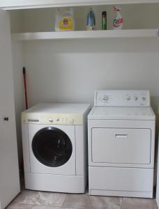 a washer and dryer in a laundry room with a sink at Mossy Hill Suite in Salt Spring Island