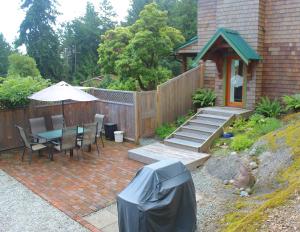 a patio with a table and chairs and an umbrella at Mossy Hill Suite in Salt Spring Island