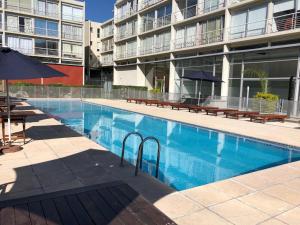 a swimming pool in front of a apartment building at Concord Pilar Suite Almendros in Pilar