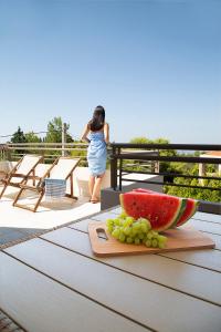 einen Tisch mit einer Schüssel Wassermelone und Trauben darauf in der Unterkunft LOTOS - Luxury Apartments in Kounoupidiana