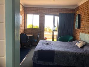a bedroom with a bed and a desk at Whale Fisher Motel in Eden
