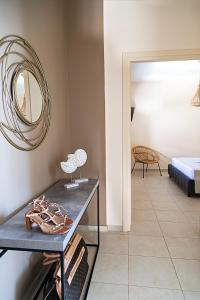 een kamer met een tafel met een spiegel en een bed bij LOTOS - Luxury Apartments in Kounoupidhianá