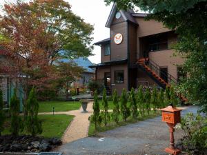 a building with a clock tower and a fire hydrant at Hotel Wellies in Karuizawa
