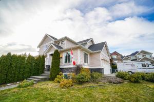 een wit huis met een busje in een tuin bij Hannah's Heavenly Home in Surrey