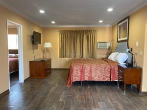 a hotel room with a bed and a window at Villa Park Motel in Orange