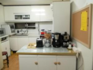 
a kitchen with a stove, sink, and refrigerator at Duri Guest House in Seoul
