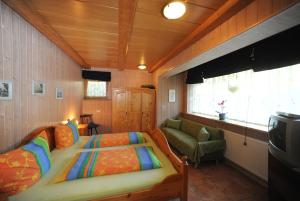 ein Schlafzimmer mit einem Bett und einem Sofa in einem Zimmer in der Unterkunft Maurer Ferienwohnungen in Bodenmais