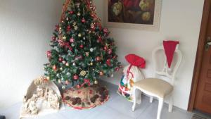 Un árbol de Navidad en una esquina de una habitación en Flats Ouro Gramado Localizado a 900 metros da entrada do Centro de Gramado, en Gramado