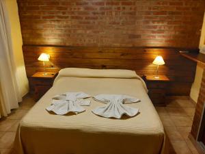 a bedroom with a bed with towels on it at Residencial Sol del Champaqui in Mina Clavero