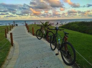 two bikes parked on a path near the beach at Apto Cond Ilhas do Caribe - Pr - Beira Mar in Matinhos