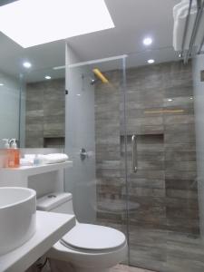 uma casa de banho com um WC e uma cabina de duche em vidro. em Ken Tehuacan em Tehuacán