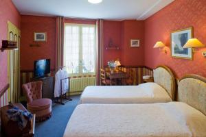 a hotel room with two beds and a television at Au Relais du Porhoet in Guilliers