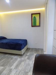 1 dormitorio con 1 cama y una pintura en la pared en Ken Tehuacan, en Tehuacán