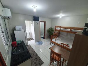 a room with a kitchen and a bedroom with a bunk bed at Kitnet Praia da Vila Imbituba in Imbituba