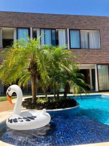 a swan float in the water in front of a building at Jardim do Rio Suítes in Florianópolis