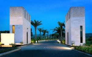 een weg voor een gebouw met palmbomen bij Le Grande Bali in Uluwatu