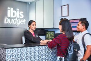 a group of people standing at abucks counter at ibis budget Singapore Mount Faber in Singapore