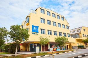 un bâtiment jaune avec un panneau bleu dans l'établissement ibis budget Singapore Mount Faber, à Singapour