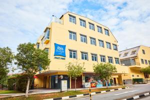 a yellow building with a blue sign on it at ibis budget Singapore Mount Faber in Singapore